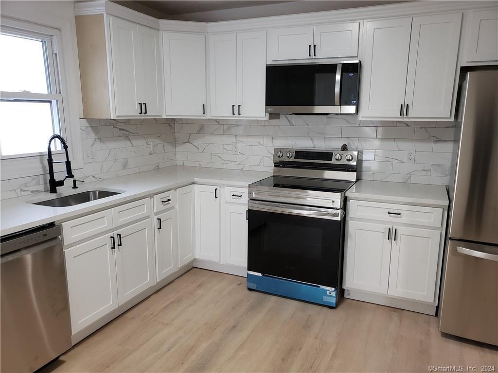 6 Lampson Street Waterbury, CT 06705 - Photo 1 of 1 a kitchen with cabinets stainless steel appliances a sink and a microwave