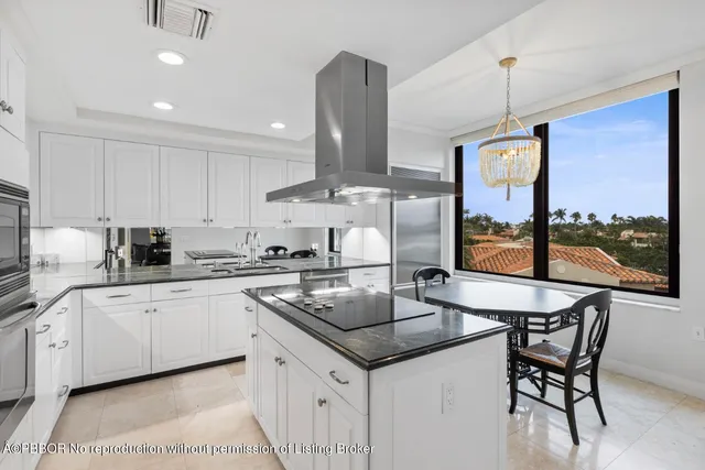 a kitchen with stainless steel appliances granite countertop a sink a stove and a wooden cabinets