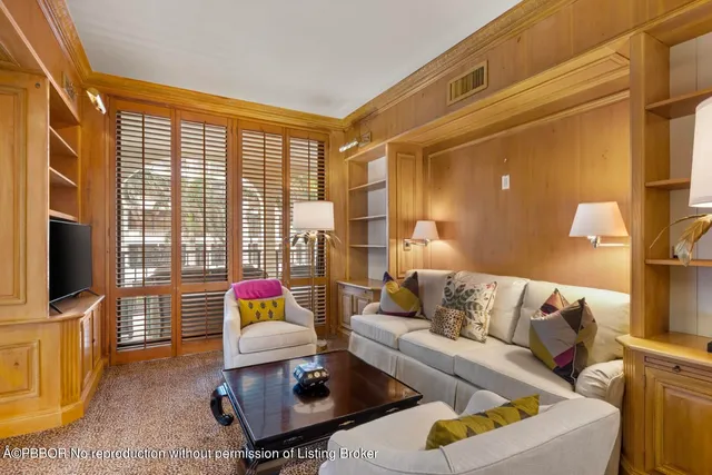 a living room with furniture flat screen tv and a large window