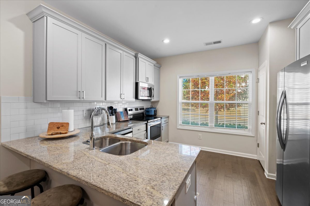 108 East River Cane Run Perry, GA 31069 - Photo 11 of 38 a kitchen with stainless steel appliances granite countertop a sink a stove and a refrigerator