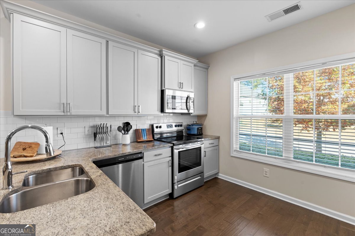 108 East River Cane Run Perry, GA 31069 - Photo 12 of 38 a kitchen with granite countertop a sink stove and cabinets