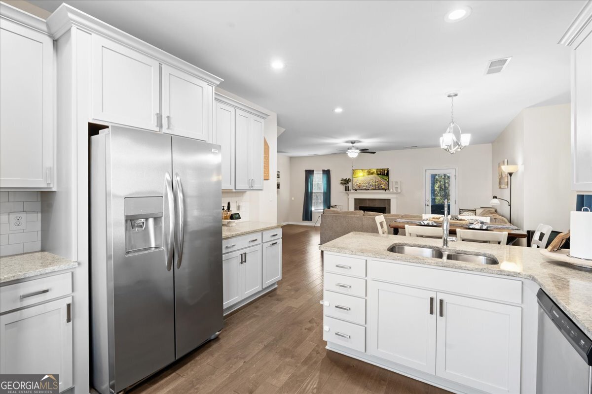 108 East River Cane Run Perry, GA 31069 - Photo 13 of 38 a kitchen with stainless steel appliances kitchen island a refrigerator sink and white cabinets