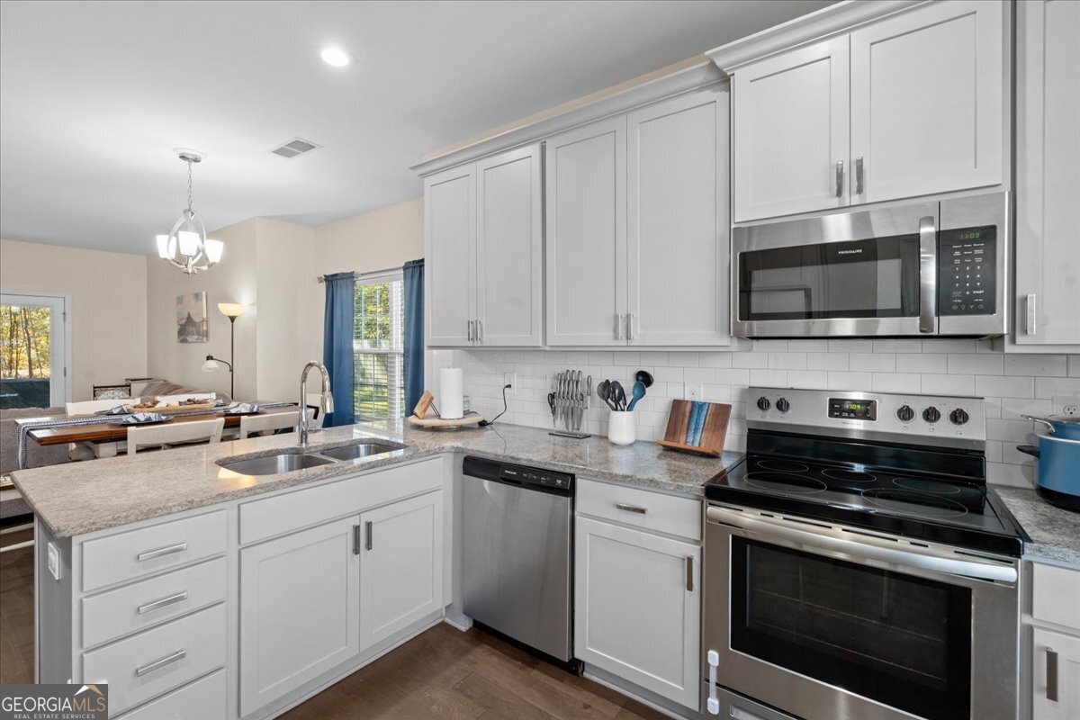 108 East River Cane Run Perry, GA 31069 - Photo 15 of 38 a kitchen with cabinets stainless steel appliances a sink and a microwave
