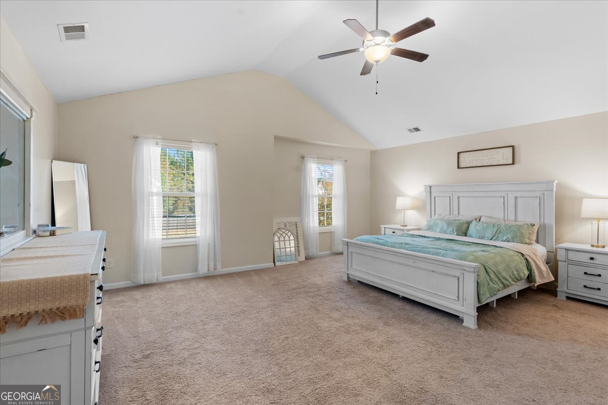 108 East River Cane Run Perry, GA 31069 - Photo 24 of 38 a spacious bedroom with a bed a chandelier and windows