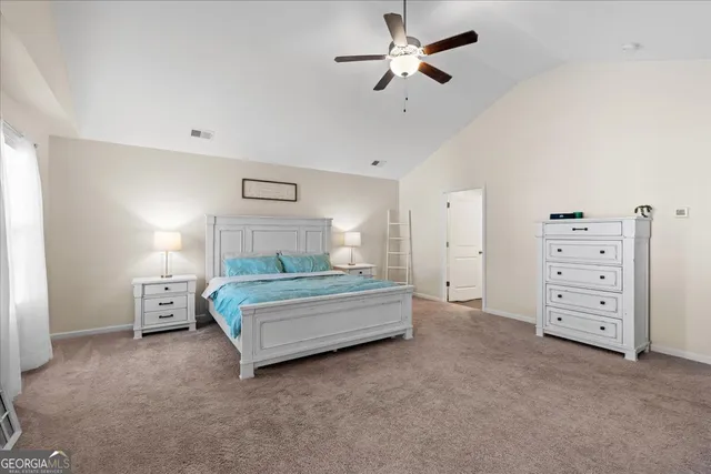 a spacious bedroom with a bed and a chandelier