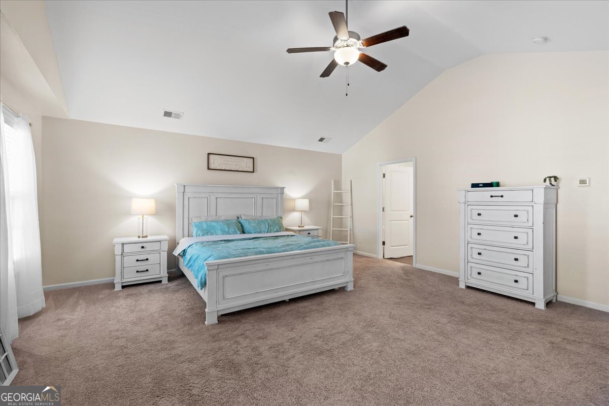 108 East River Cane Run Perry, GA 31069 - Photo 25 of 38 a spacious bedroom with a bed and a chandelier