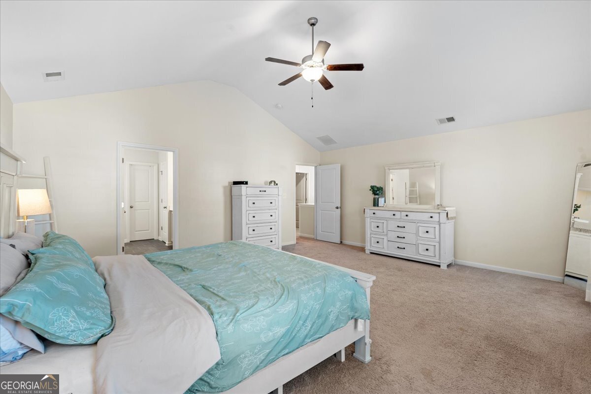 108 East River Cane Run Perry, GA 31069 - Photo 26 of 38 a spacious bedroom with a bed a ceiling fan and a couch