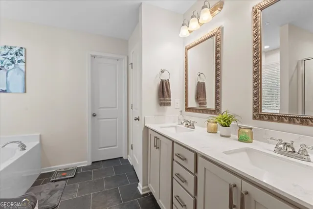 a spacious bathroom with a double vanity sink a mirror and a bathtub
