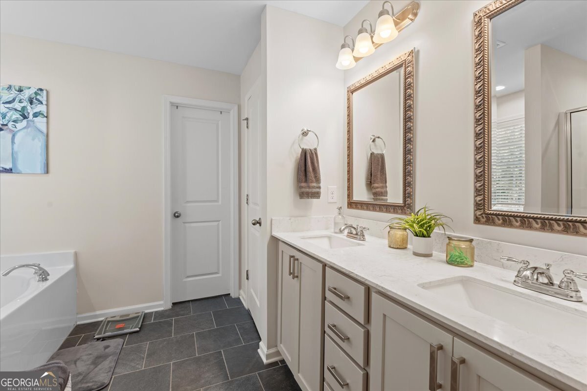 108 East River Cane Run Perry, GA 31069 - Photo 28 of 38 a spacious bathroom with a double vanity sink a mirror and a bathtub