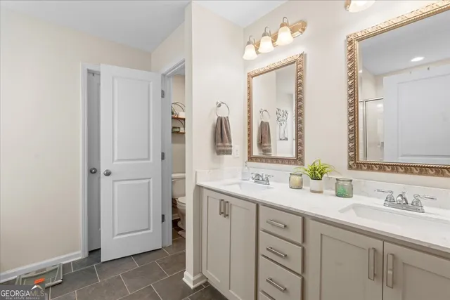 a bathroom with a double vanity sink mirror and next to a window