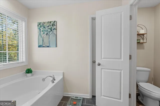 a white bath tub sitting next to a toilet