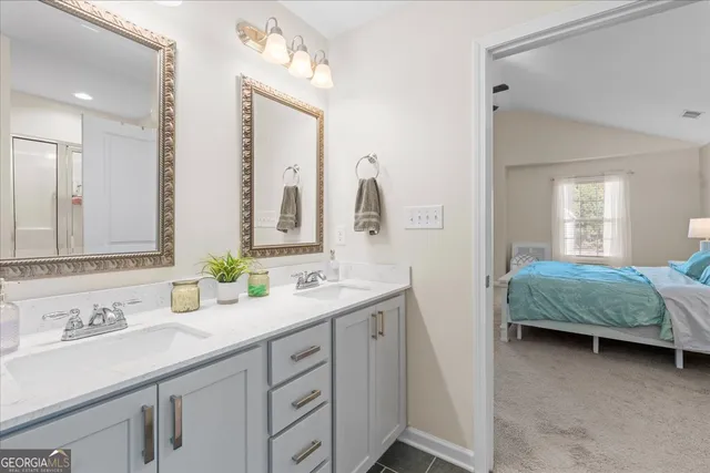 a en suite bathroom with a double vanity sink and a mirror