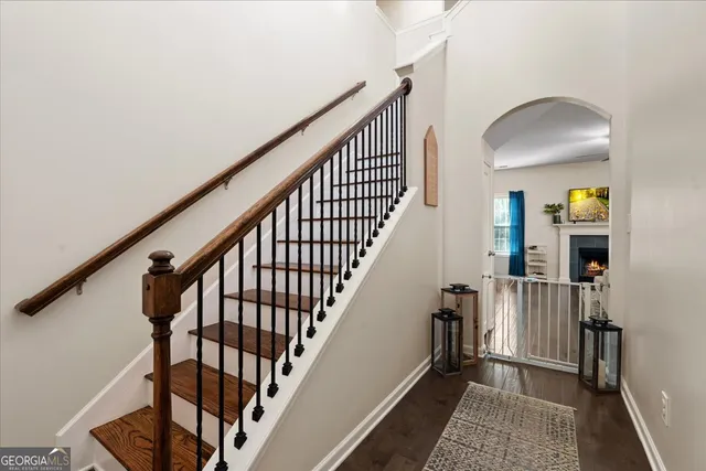 a view of staircase with wooden floor and a rug
