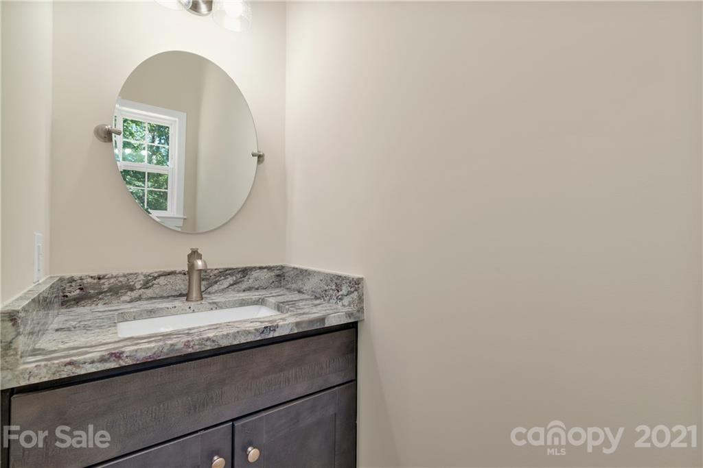 275 Ridge View Drive, Unit 1 Clyde, NC 28721 - Photo 11 of 22 a bathroom with a granite countertop sink and a mirror