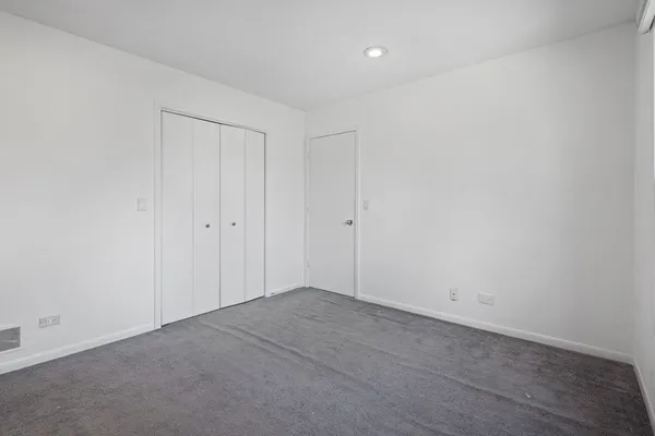 an empty room with a ceiling fan and a window