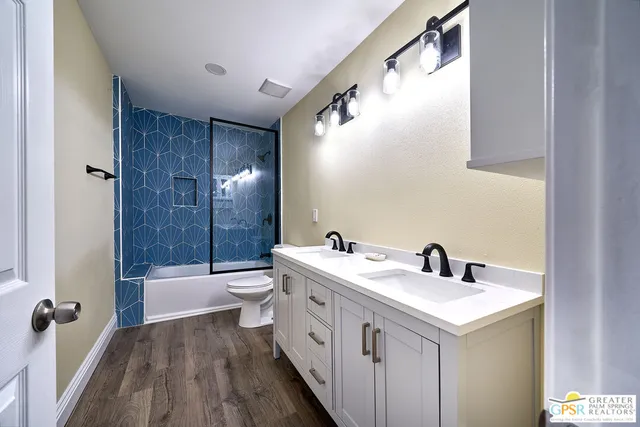 a bathroom with a double vanity sink toilet and shower