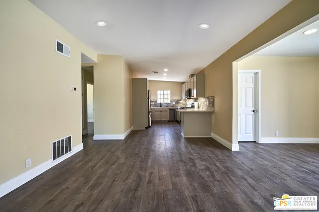 a view of a kitchen with wooden floor and electronic appliances