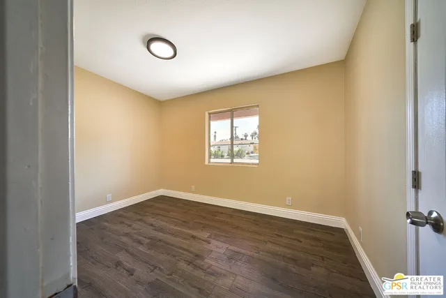 a view of an empty room with wooden floor