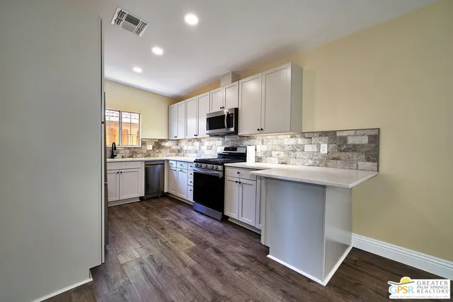 a kitchen with a sink cabinets and wooden floor