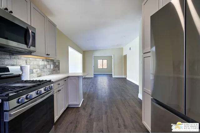 a kitchen with stainless steel appliances a stove a sink and a microwave