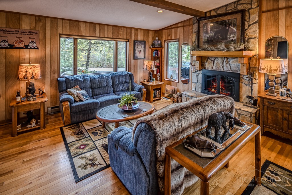 103-105 Upper Grouse Ridge Road Beech Mountain, NC 28604 - Photo 16 of 48 a living room with furniture a fireplace and a floor to ceiling window