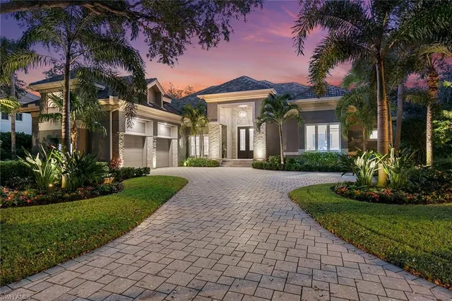 a front view of a house with a yard and potted plants