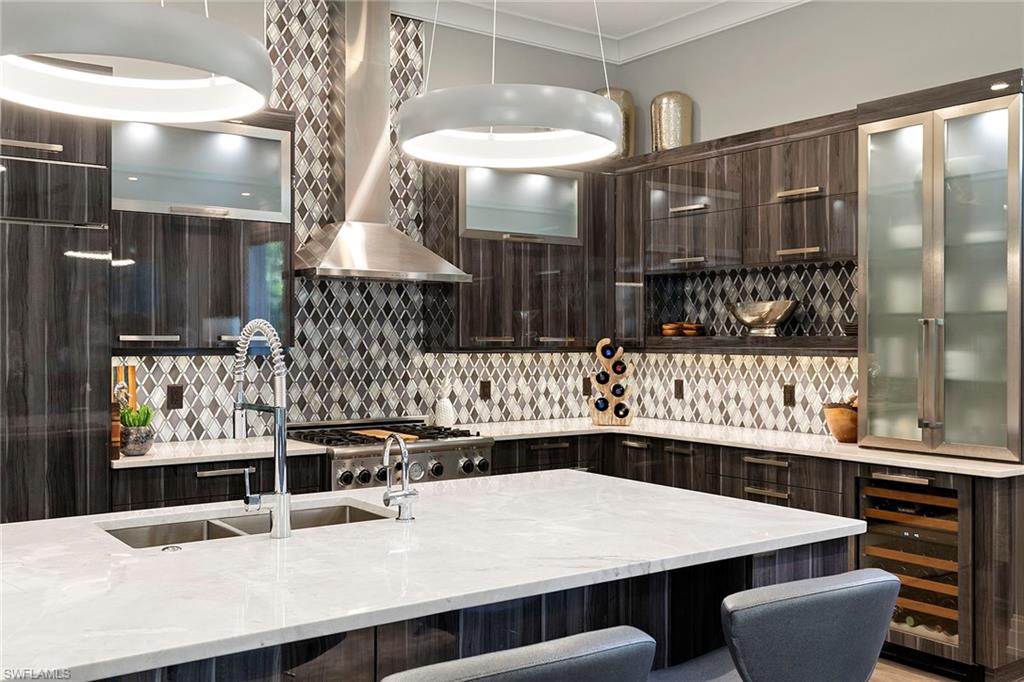 927 Barcarmil Way Naples, FL 34110 - Photo 13 of 48 a kitchen with a table chairs and white cabinets