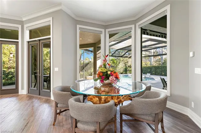 a dining room with furniture window and wooden floor