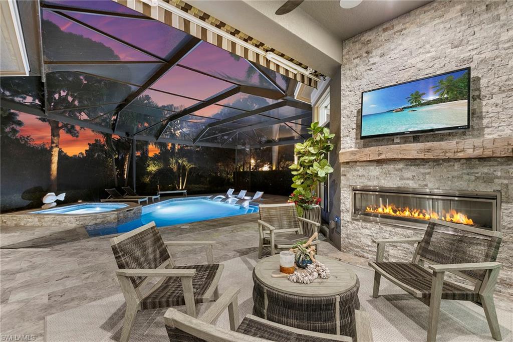 927 Barcarmil Way Naples, FL 34110 - Photo 2 of 48 a view of a patio with a dining table and chairs with a fireplace