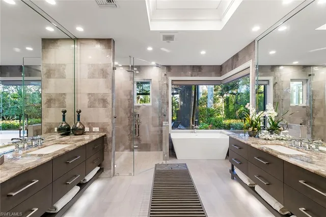 a bathroom with a double vanity sink a large mirror and shower