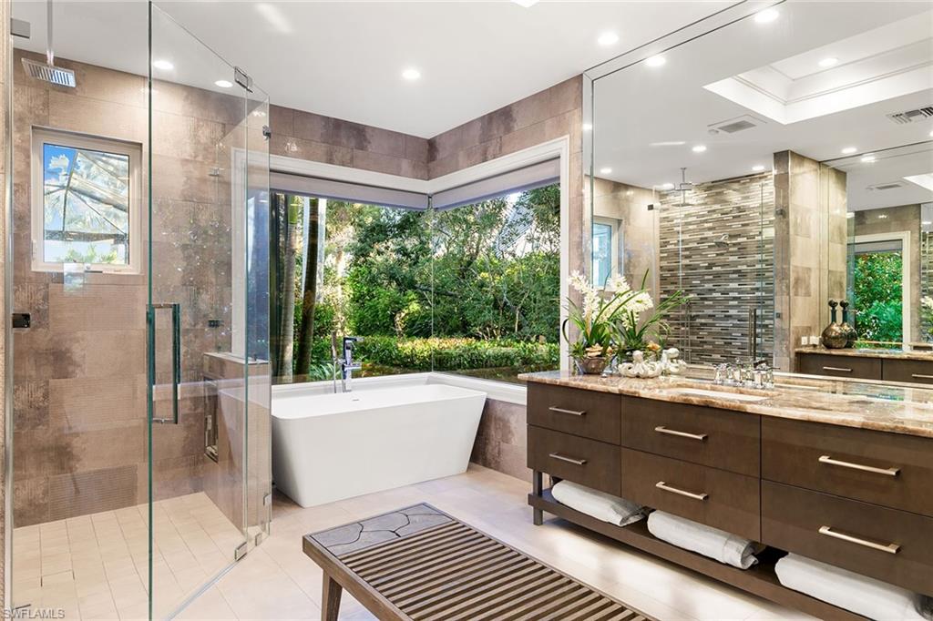 927 Barcarmil Way Naples, FL 34110 - Photo 24 of 50 Bathroom with vanity, a shower stall, a freestanding bath, tile walls, and recessed lighting