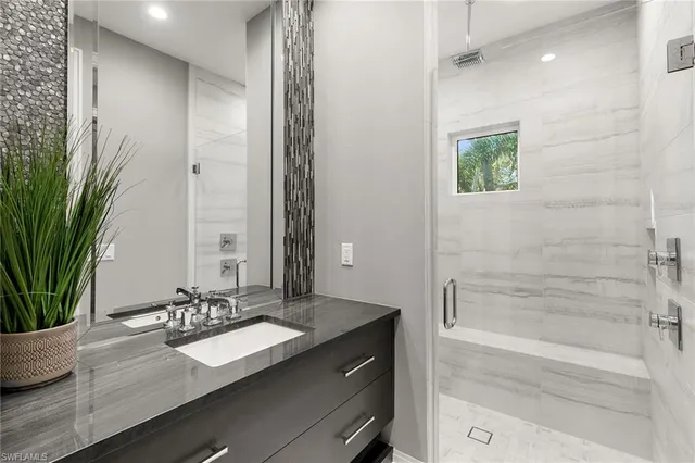 a bathroom with a granite countertop sink a mirror and a shower