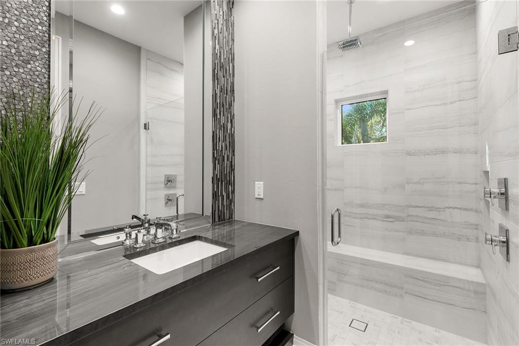 927 Barcarmil Way Naples, FL 34110 - Photo 26 of 50 Bathroom with a marble finish shower and vanity