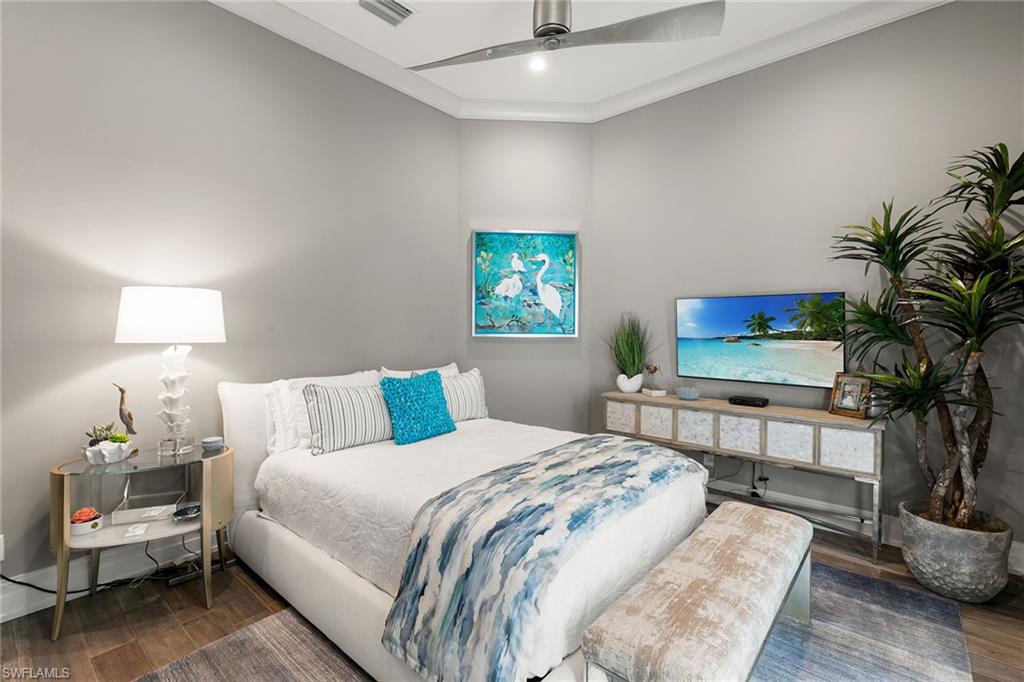 927 Barcarmil Way Naples, FL 34110 - Photo 29 of 48 a bedroom with a bed and a potted plant