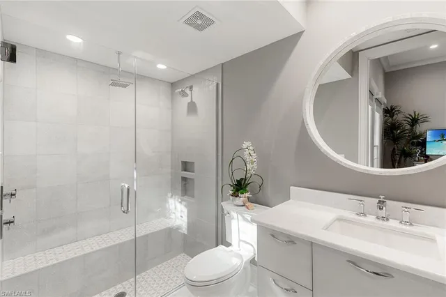 a bathroom with a sink a toilet and shower