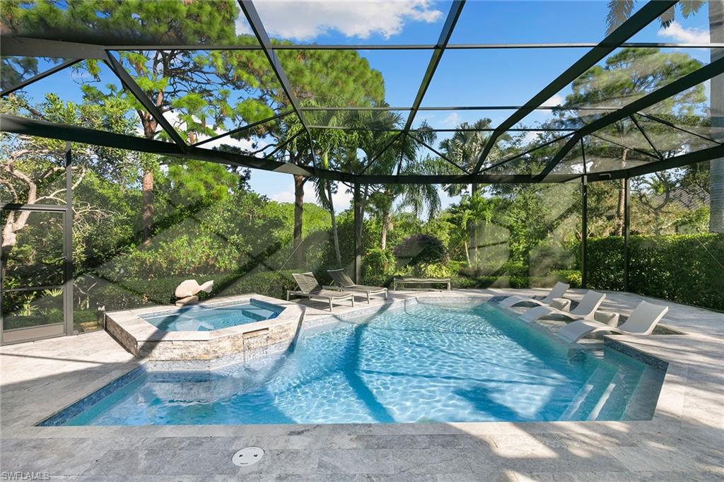 927 Barcarmil Way Naples, FL 34110 - Photo 4 of 50 Integrated pool / spa with a sunroom, glass enclosure, and a patio