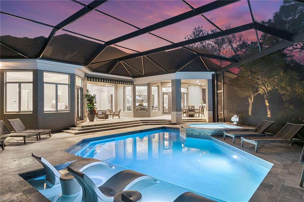 927 Barcarmil Way Naples, FL 34110 - Photo 44 of 50 Relaxing pool / spa with glass enclosure, outdoor dining space, and a patio