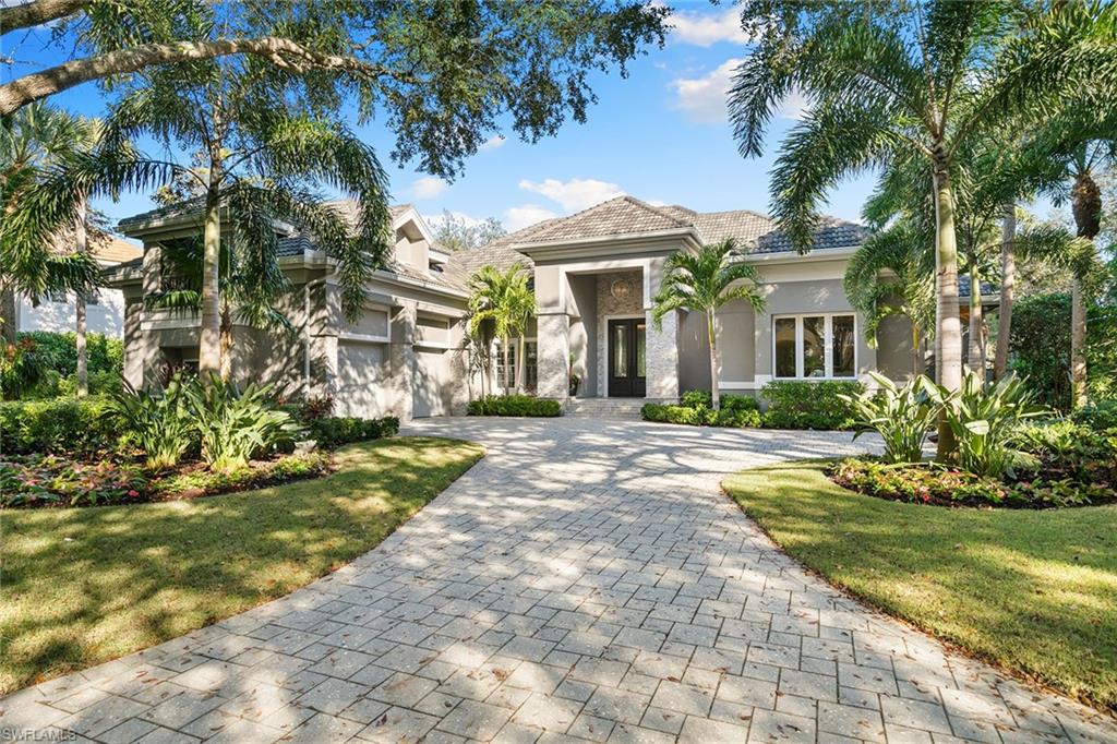 927 Barcarmil Way Naples, FL 34110 - Photo 49 of 50 View of front of house featuring stucco siding, decorative driveway, a garage, and a front yard