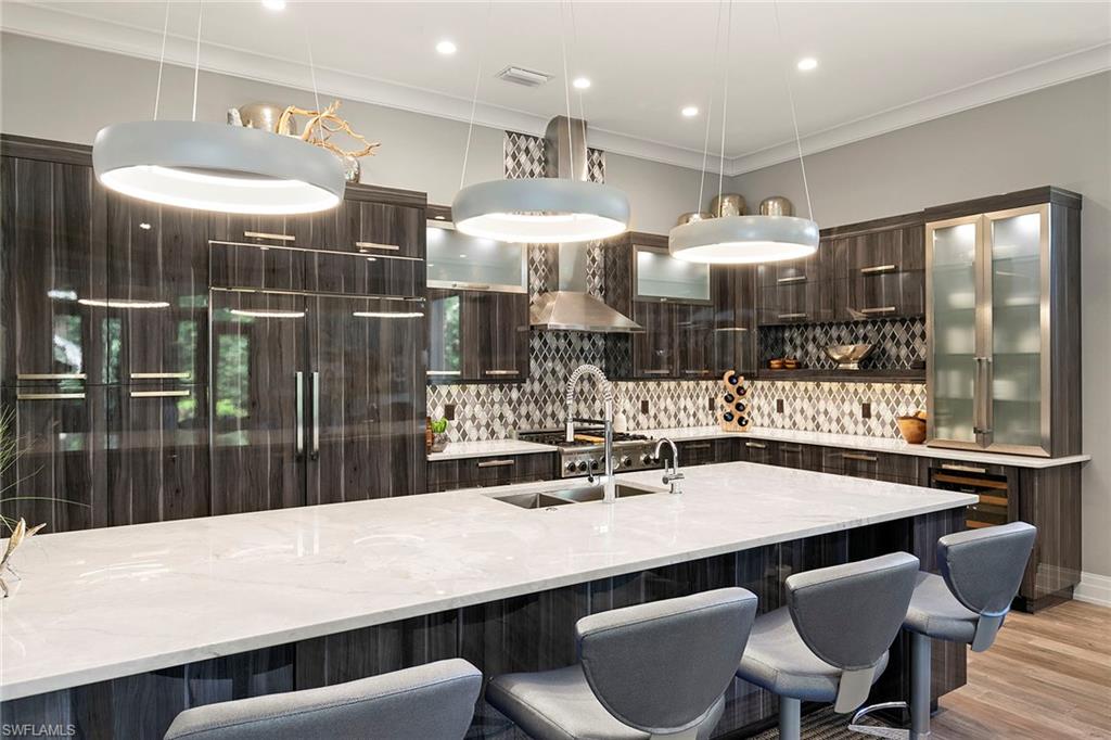 927 Barcarmil Way Naples, FL 34110 - Photo 10 of 48 a kitchen with a table and chairs