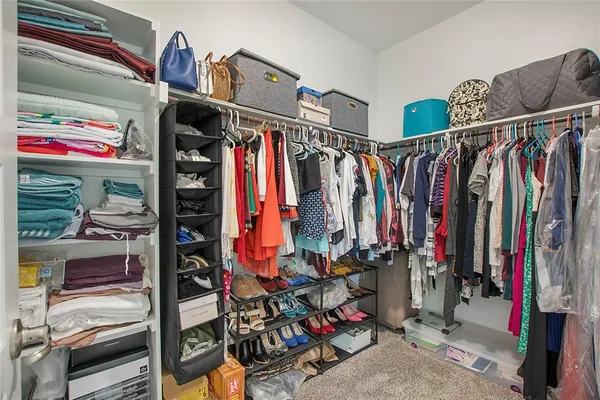 a view of walk in closet with clothes