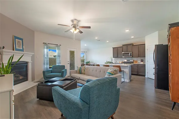 a living room with furniture kitchen view and a refrigerator