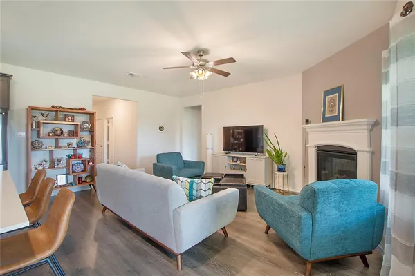 a living room with furniture a flat screen tv and a fireplace