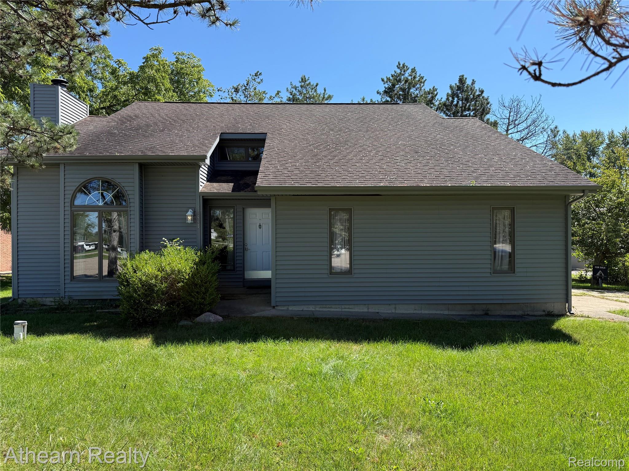 11449 Torrey Road Fenton, MI 48430 - Photo 1 of 30 Exterior featuring gray horizontal siding, an arched window, a dormer window, and a prominent front door