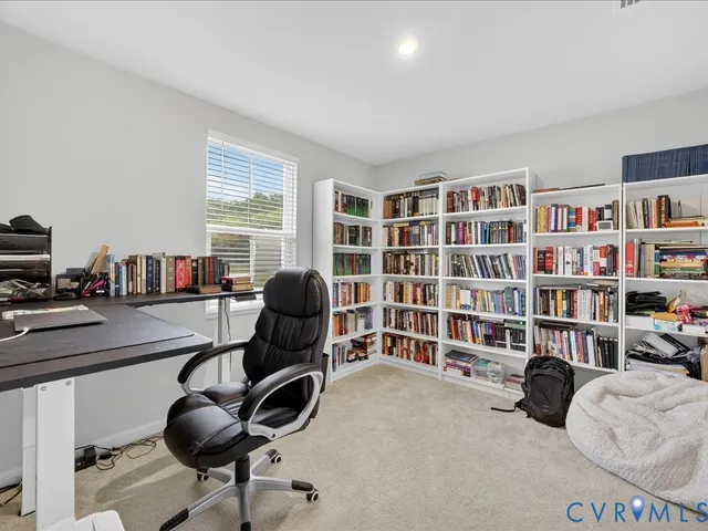 a view of a livingroom with workspace and a bookshelf