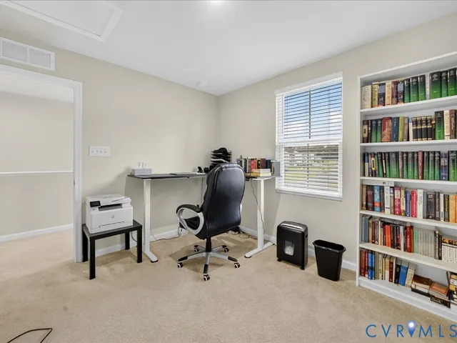 a view of a workspace with furniture and a bookshelf