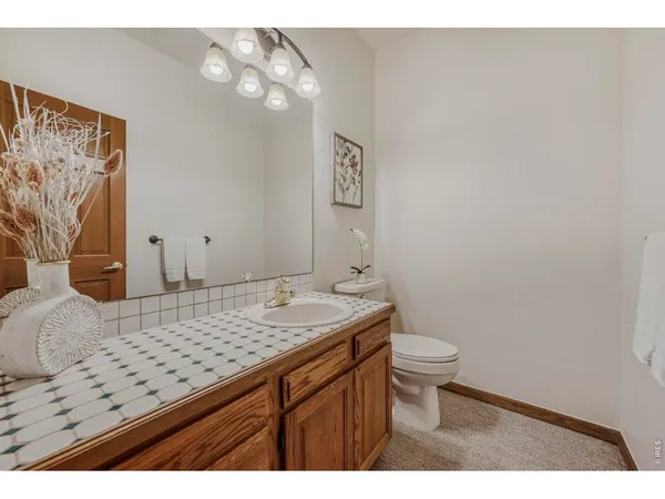 a bathroom with a granite countertop sink a toilet and a mirror