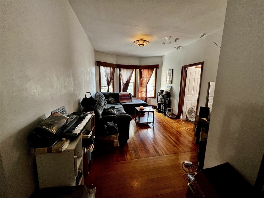 63 Sycamore Street, Unit 2 Somerville, MA 02145 - Photo 2 of 9 a living room with furniture and a wooden floor