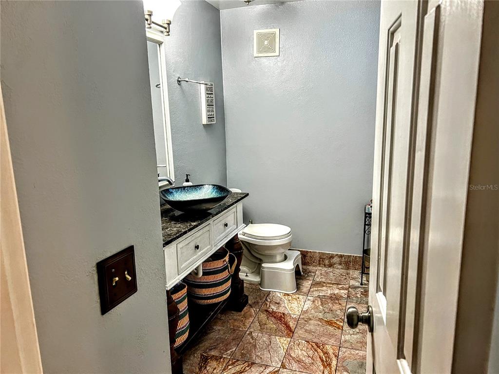 4515 Orangewood Loop East Lakeland, FL 33813 - Photo 14 of 39 a bathroom with a granite countertop toilet and a sink
