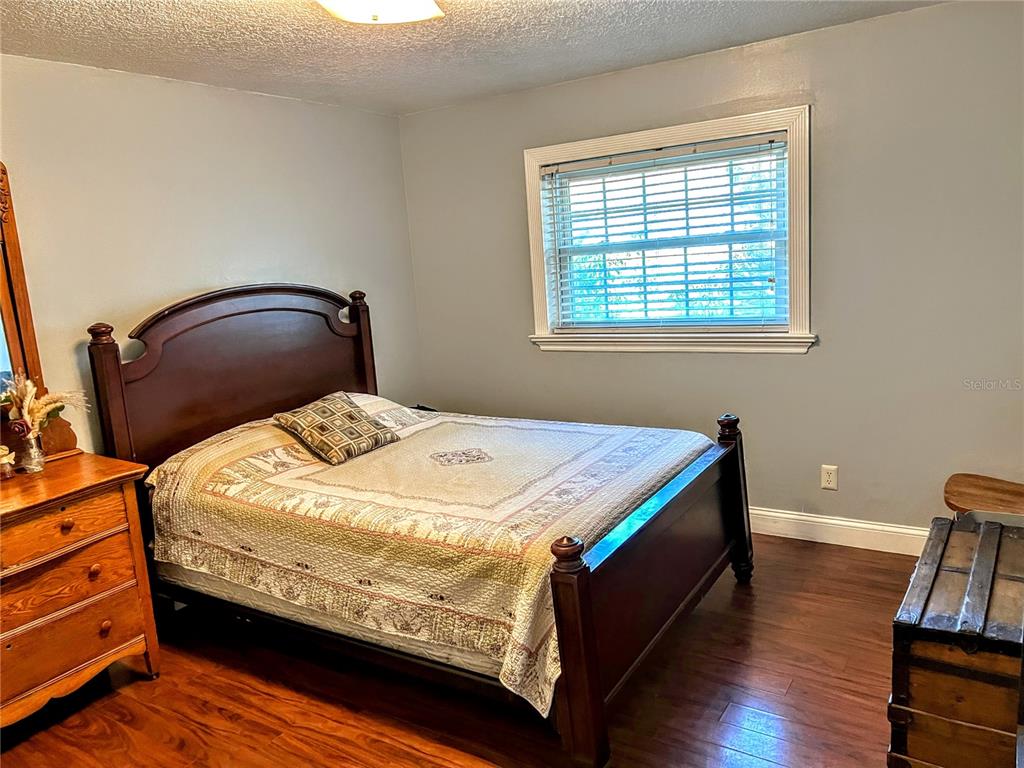 4515 Orangewood Loop East Lakeland, FL 33813 - Photo 16 of 39 a bedroom with bed and wooden floor