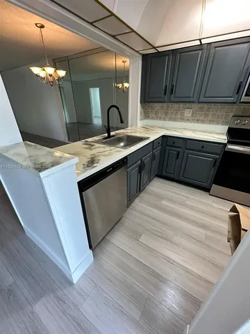 a kitchen with stainless steel appliances kitchen island granite countertop a sink and a stove